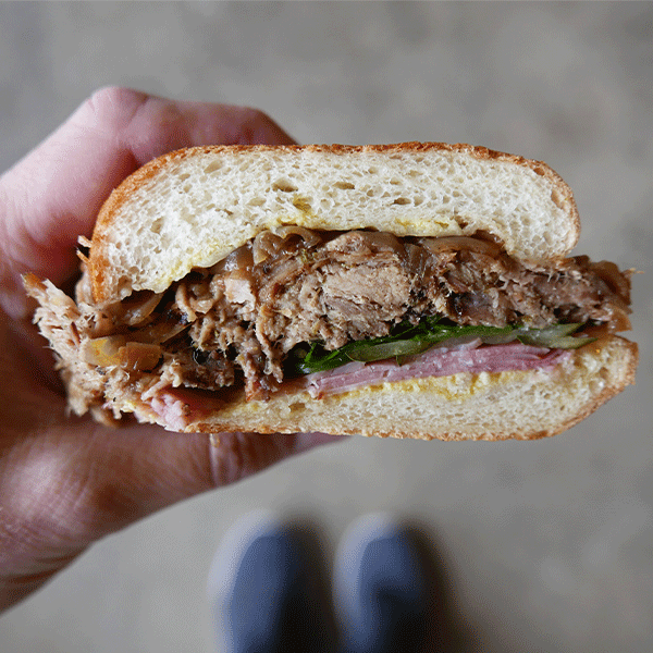 Hand holding a Cubano sandwich
