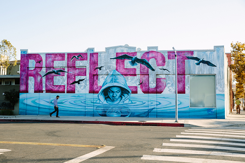 "Reflect" mural with person emerging from water