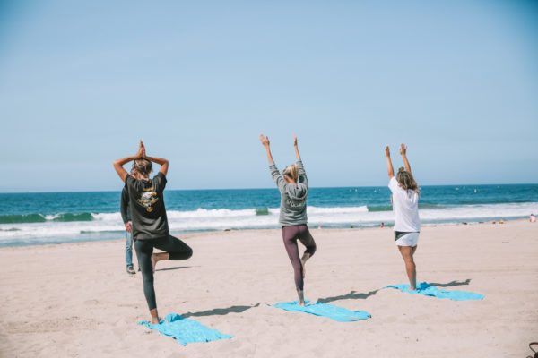 Three woman doing yoga on Santa Monica Beach