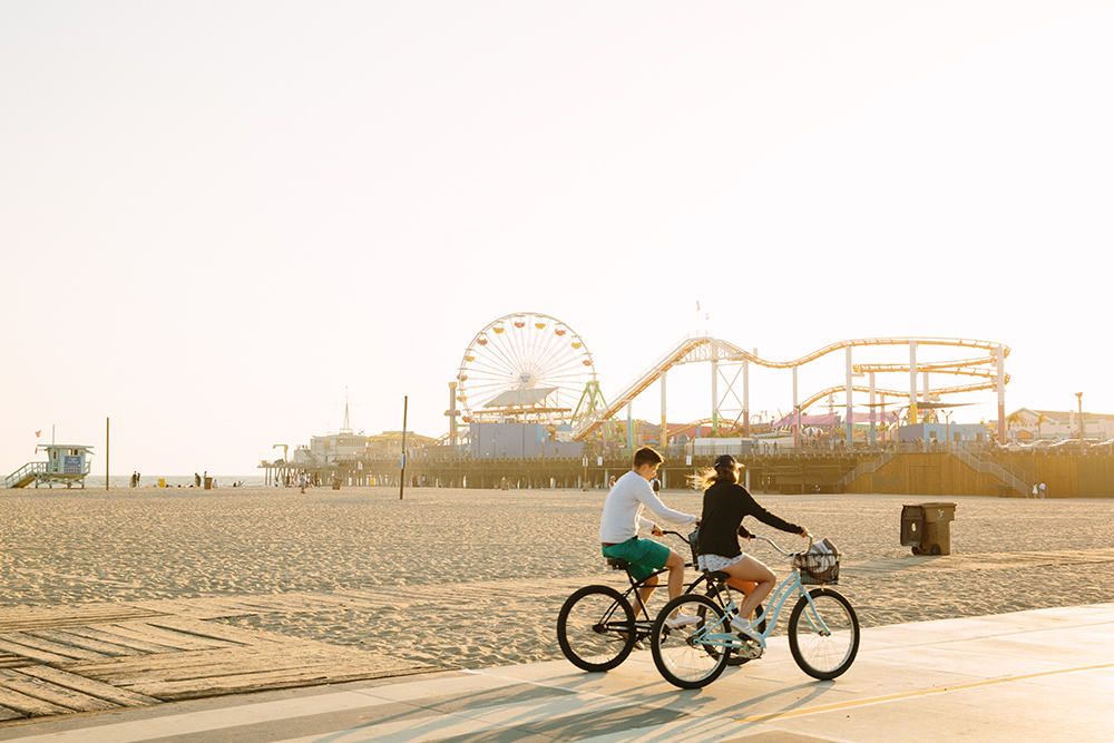 Two people riding bikes along Santa Monica beach