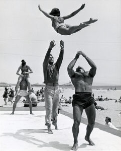 Acrobats throwing a girl in the air at Santa Monica Muscle Beach in 1953.