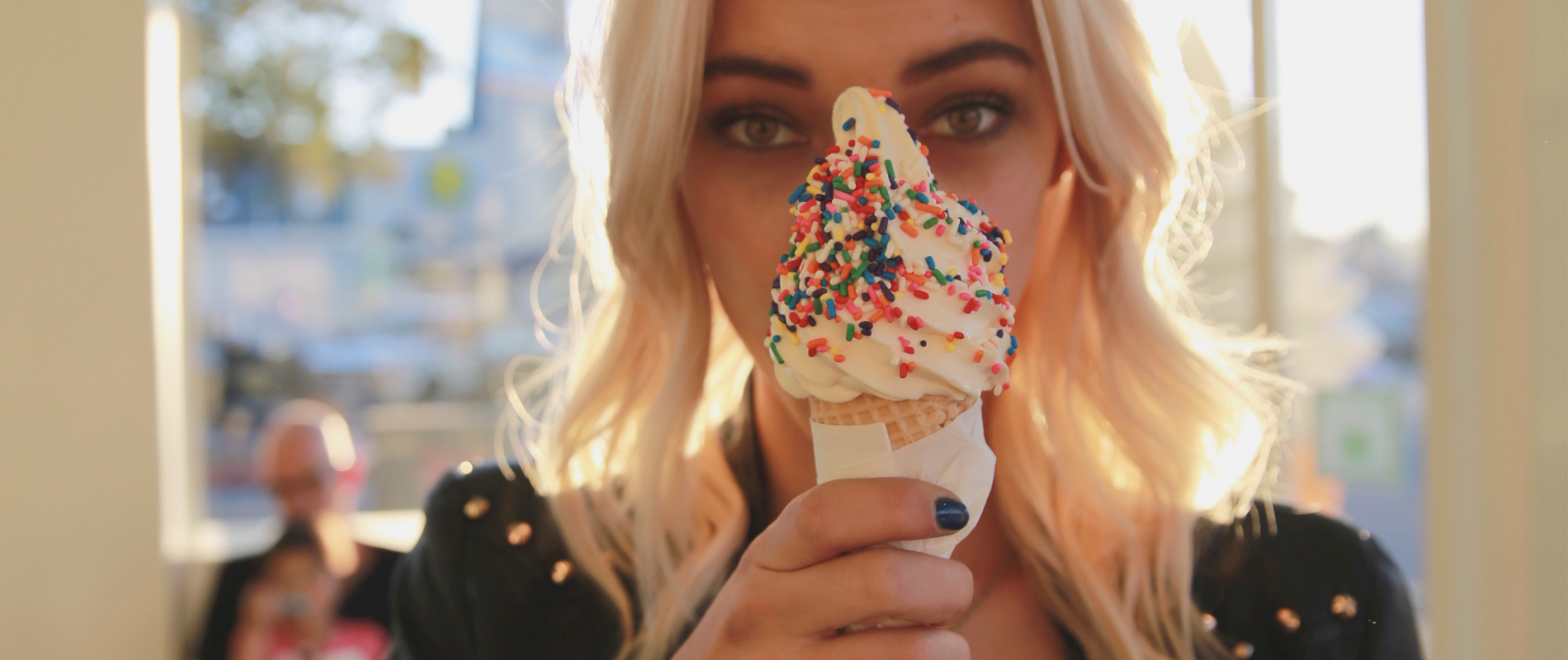 A girl eating an ice cream cone with sprinkles on top at Treats Frozen Yogurt and Ice in Santa Monica.