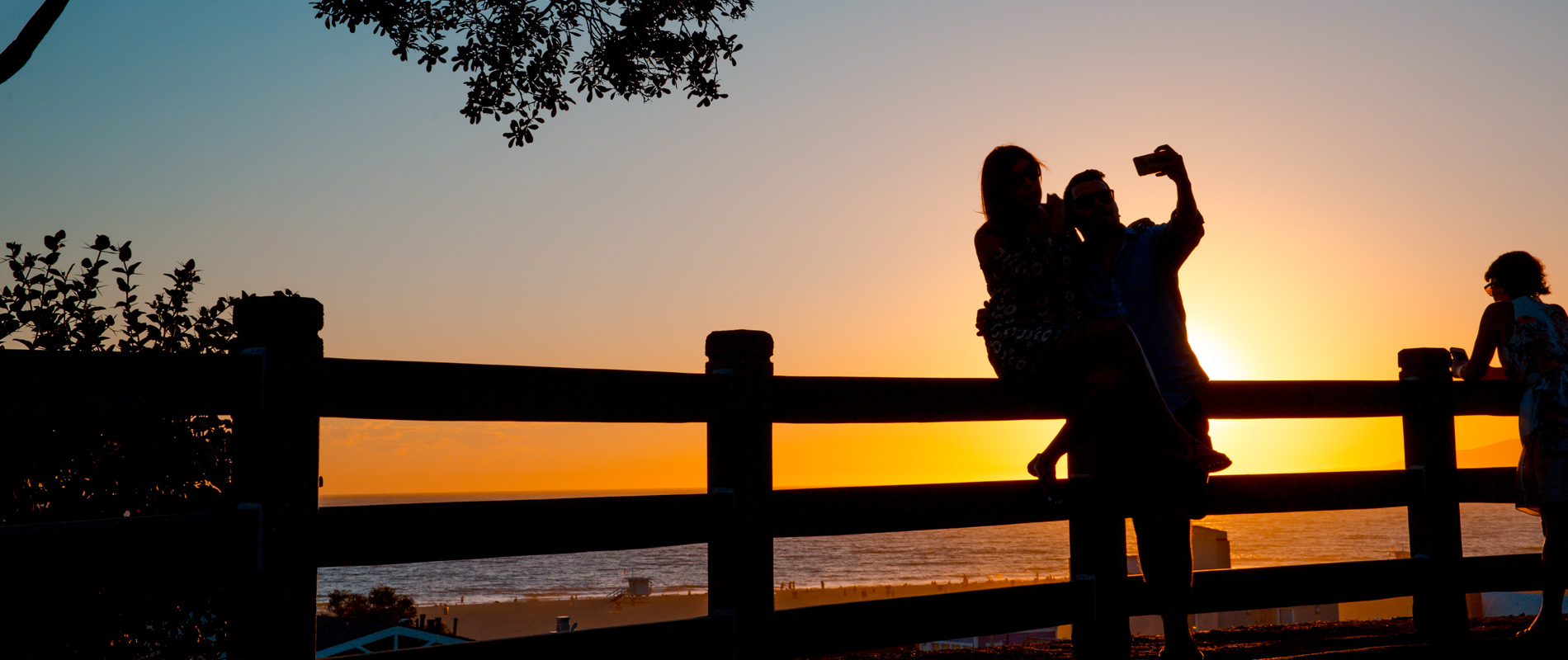 A couple taking a selfie on Santa Monica Bluffs during sunset
