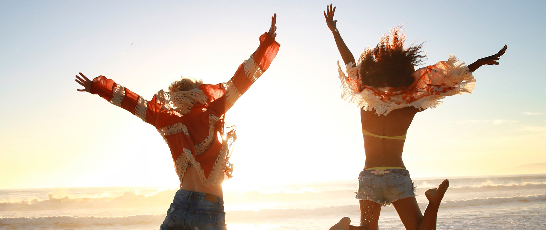 Two women jumping on Santa Monica Beach