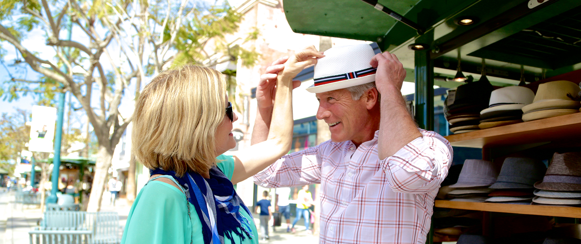 Couple trying on hats on Third Street Promenade in Santa Monica