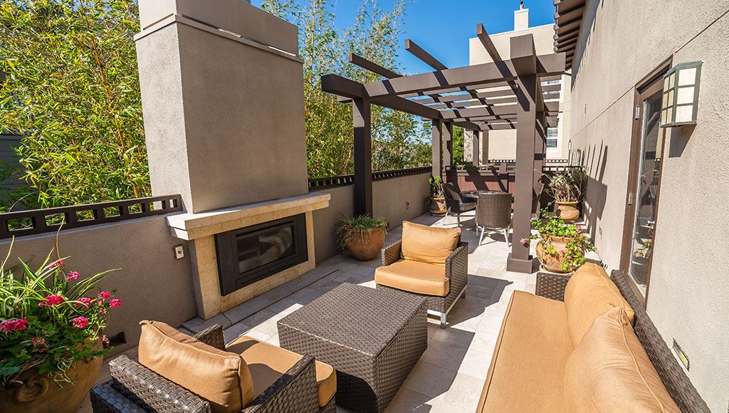 Back patio area with seating and a fireplace at The Ambrose Hotel Santa Monica