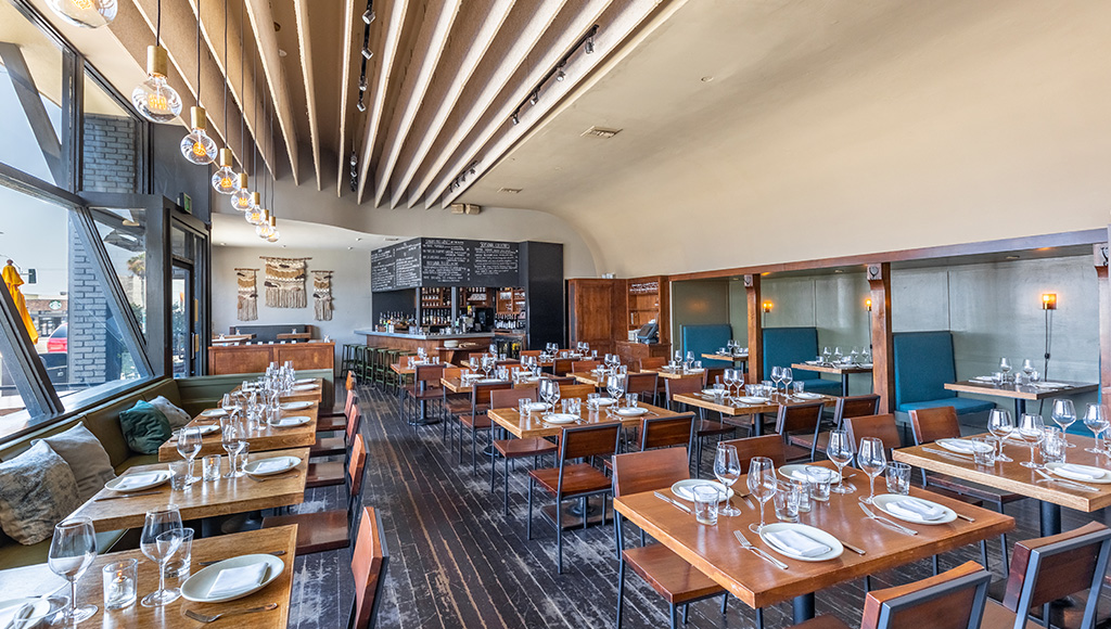 Restaurant ready to open; tables set and natural light coming in from the window