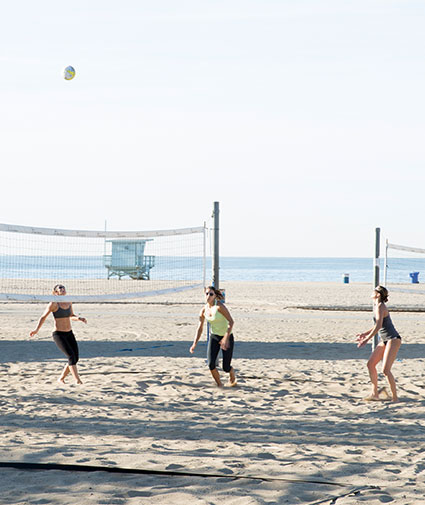 Three women playing beach volleyball in on Santa Monica Beach