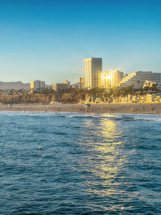 View of the Santa Monica coast from the water during sunset.