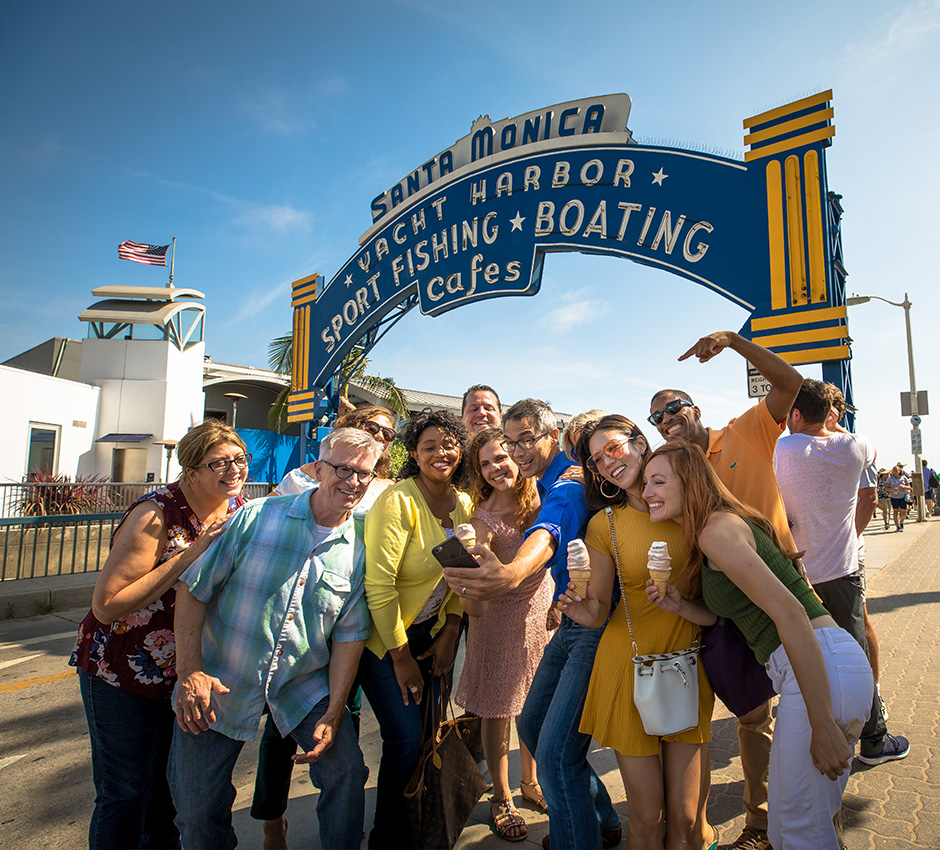 Group of professionals smiling for a photo; photo at Santa Monica Pier