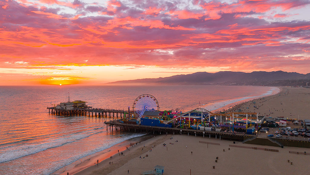Red, pink, purple and orange sunset over Santa Monica Pier and Santa Monica Beach