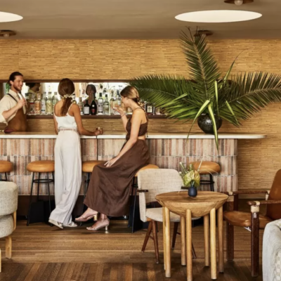 Picture of two women laughing at bar drinking champagne at Palma Bar at Santa Monica Proper Hotel