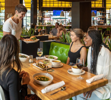 服务员向一桌妇女递送食物